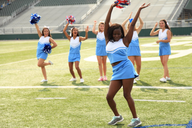 六个拉拉队队员在足球场练习。图片下载