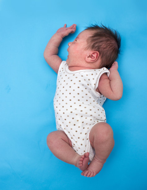 高角度的婴儿女孩哭在蓝色的背景图片下载