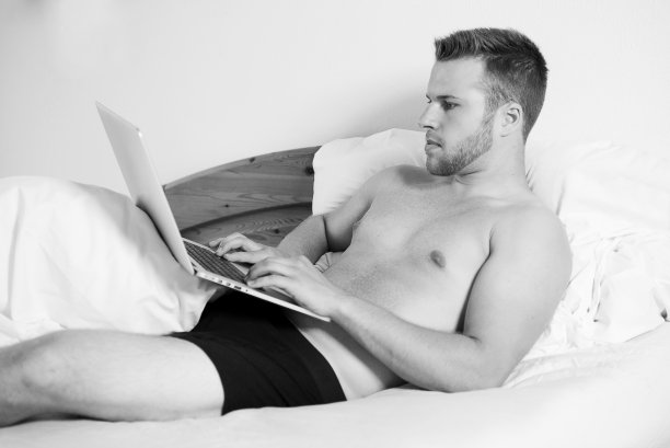 一个年轻人在他的笔记本电脑前图片下载