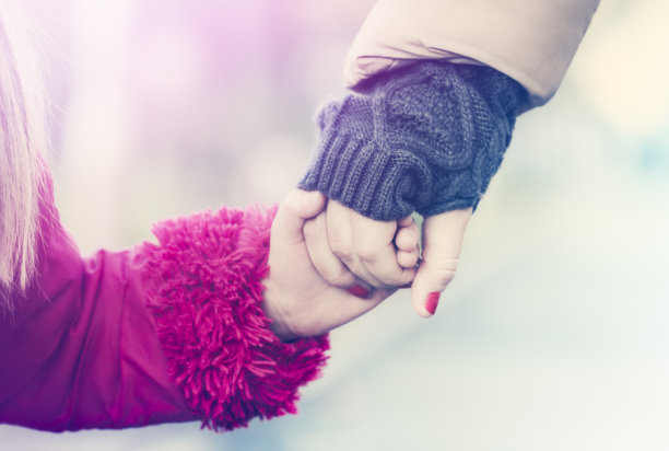 母亲和女儿牵着手的街道特写镜头图片下载