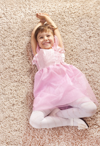 快乐的小女孩躺在地板上图片下载