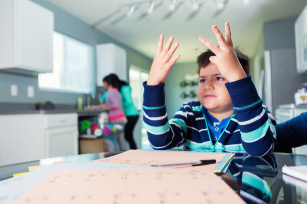 沮丧的小男孩在做数学作业图片下载
