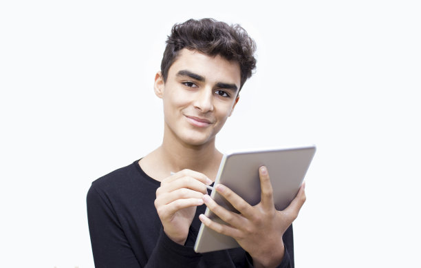 在白色背景上使用平板电脑微笑的男孩肖像图片下载