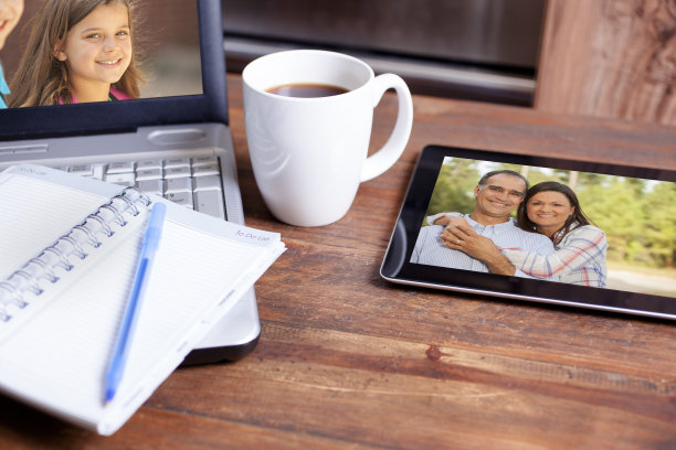 科技:笔记本电脑，桌上的数字平板电脑。家庭照片。图片下载