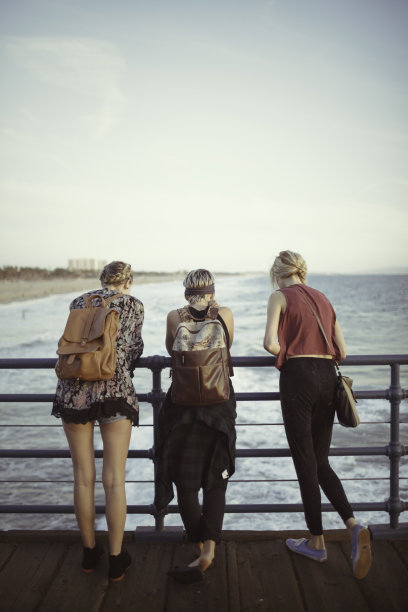 三个年轻女人在码头边看鱼图片下载