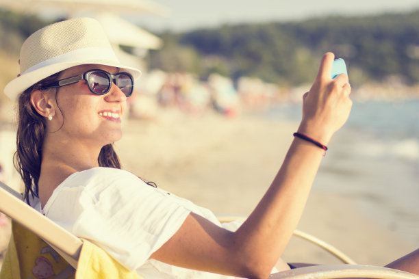 美丽的年轻女子在热带海滩上自拍图片下载