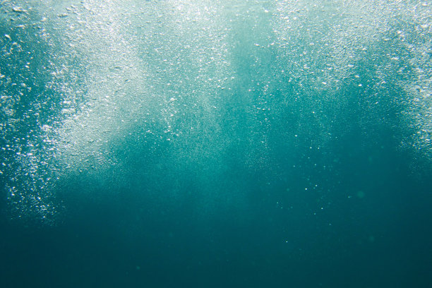 海水的泡沫在黑色的水中上升图片下载