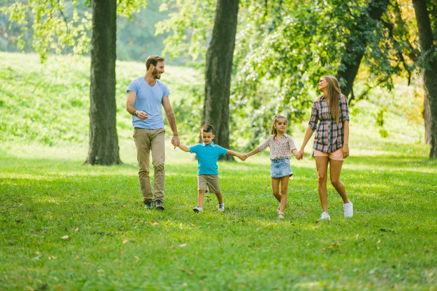 快乐的家庭享受他们的夏日漫步在公园。图片下载