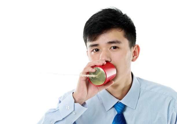 亚洲商人对着一个罐头打电话图片下载