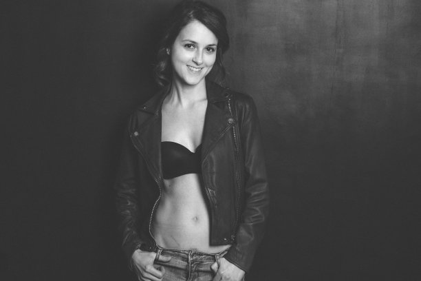 微笑的女人在黑色背景下摆姿势图片下载