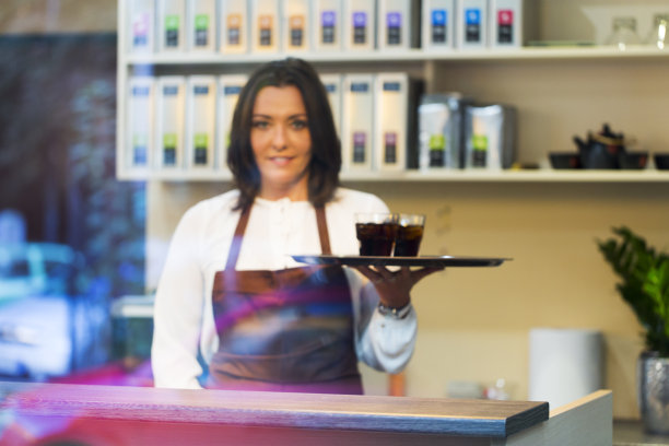 咖啡店里卖冷饮的可爱年轻女服务生图片下载