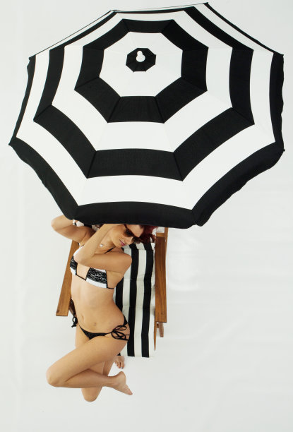 上面的观点比基尼女人坐在甲板上的椅子上图片下载