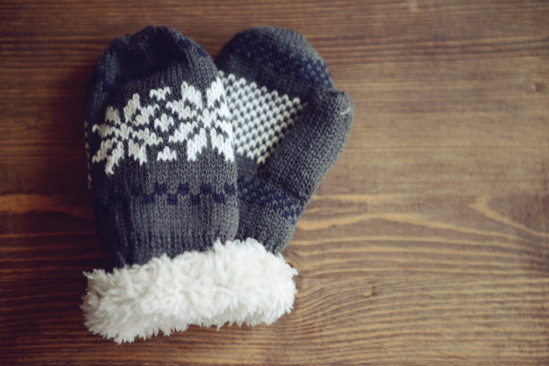 木制背景上编织的羊毛手套图片下载