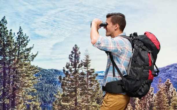 带着双筒望远镜在户外搜寻的背包客图片下载