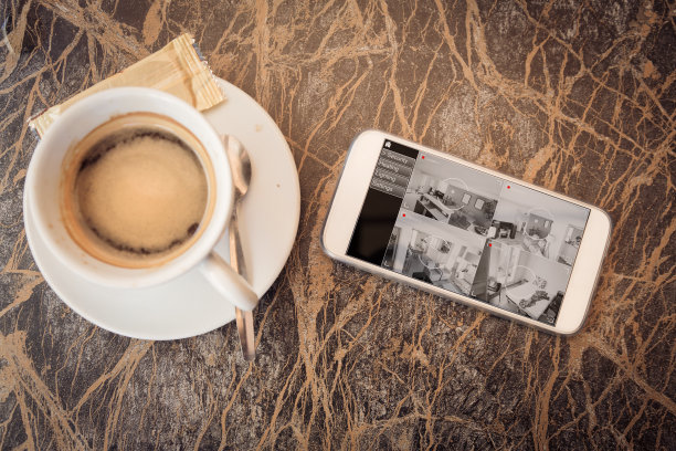 手机屏幕上显示了家里监控摄像头的视频素材图片