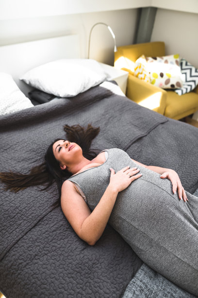 孕妇躺在床上休息图片下载