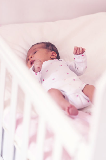 新生儿在婴儿床中醒来图片下载
