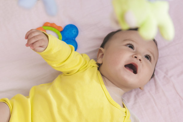 顽皮的婴儿躺在他的婴儿床微笑素材图片