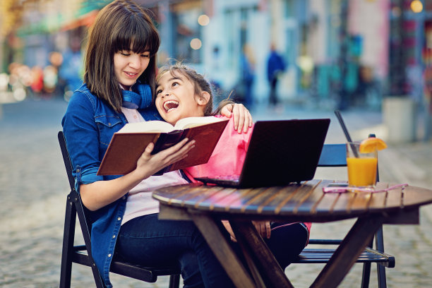 姐姐在自助餐厅给妹妹读书图片下载