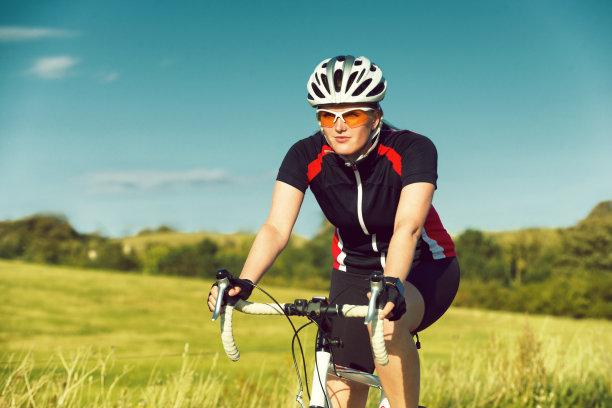 女自行车手微笑着把自行车往前推图片下载