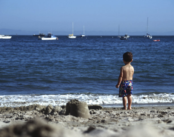 男孩看着蓝色的海洋图片下载