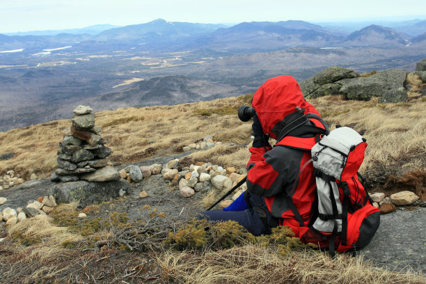 男摄影师在山顶用单反相机拍照图片下载