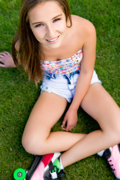 年轻女子坐在草地上图片下载