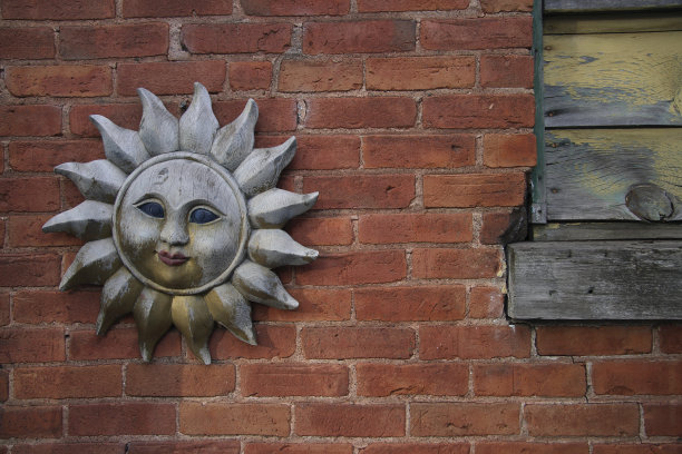 花园墙用褪色的木头作太阳装饰。图片下载