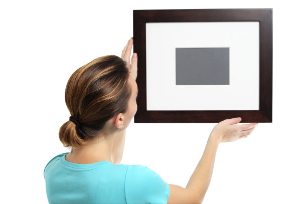 年轻女子挂画框孤立在白色背景图片下载