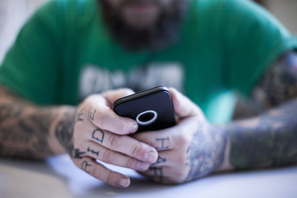 纹身男子使用智能手机图片下载