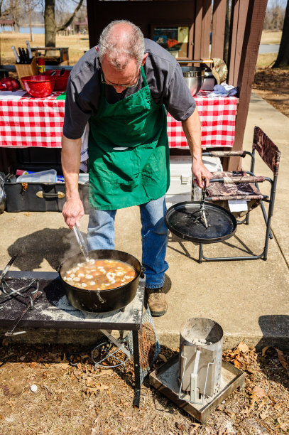 男人在荷兰烤炉里搅拌食物图片下载