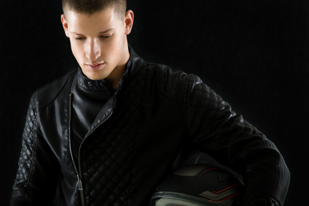 一个戴着头盔穿着皮夹克的摩托车手的肖像图片下载