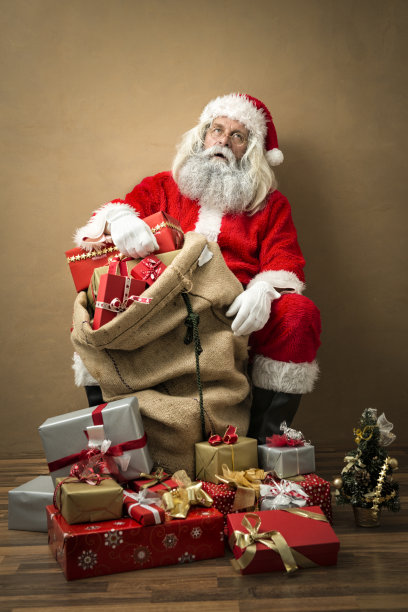 看起来疲惫的圣诞老人带着许多礼物图片下载