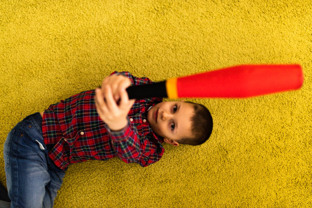 上图是小男孩在地毯上玩玩具。图片下载