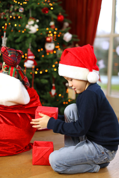 快乐的孩子从圣诞老人的袋子里拆圣诞礼物图片下载