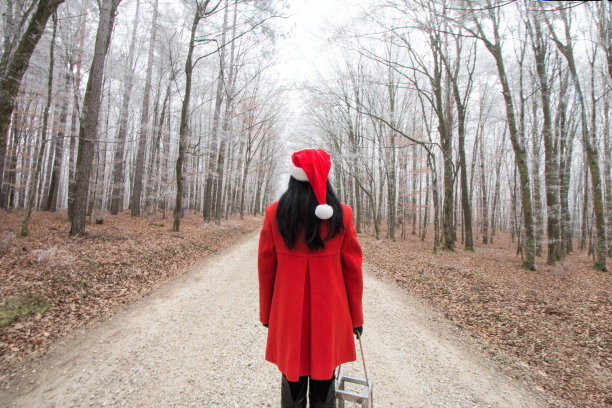 圣诞妇女在路上戴着圣诞老人的帽子图片下载