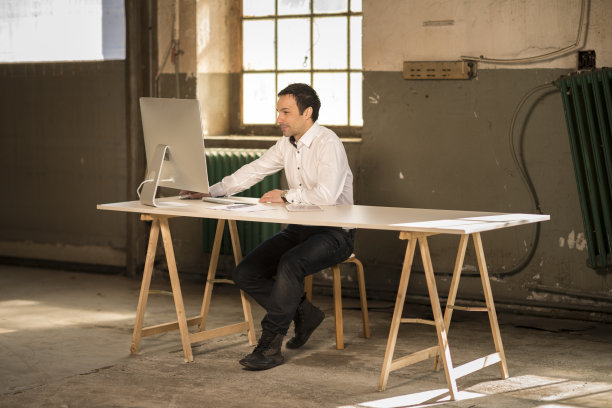 商人在旧工厂用电脑工作图片下载