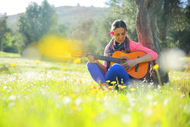 年轻女子在户外拿着吉他图片下载