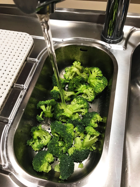 食物背景:在厨房的水龙头下清洗生西兰花图片下载