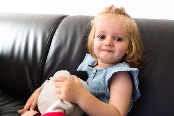 一个小孩在沙发上玩木偶图片下载