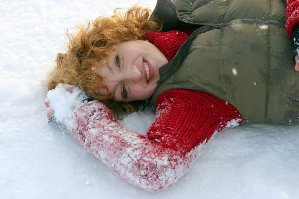 微笑的女人躺在雪地里图片下载