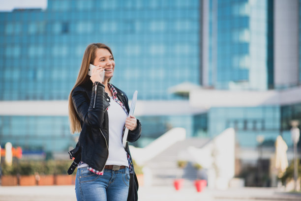 女网页设计师一边走在街上一边打电话图片下载