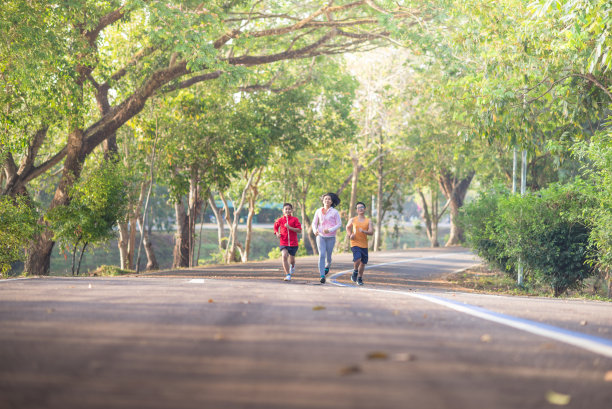 家庭运动快乐活跃的母亲和孩子在户外慢跑，在森林里跑步图片下载