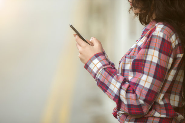 年轻女子在墙边打电话图片下载