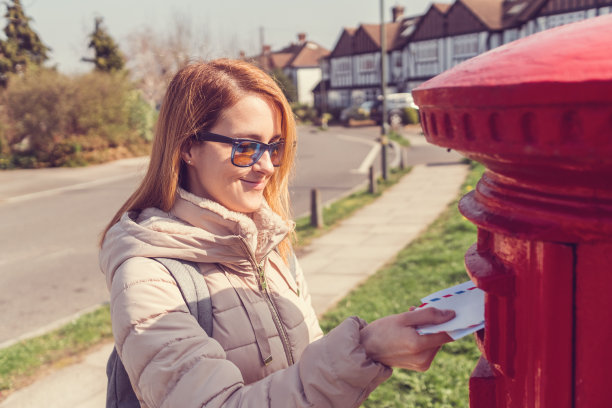 在伦敦的一个妇女在公共邮箱里寄信图片下载