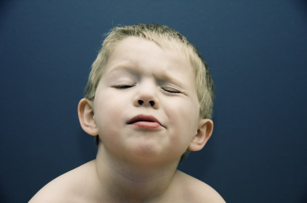 小男孩滑稽的脸在眨眼图片下载