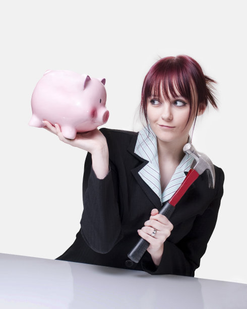 带着存钱罐和锤子的漂亮女商人图片下载