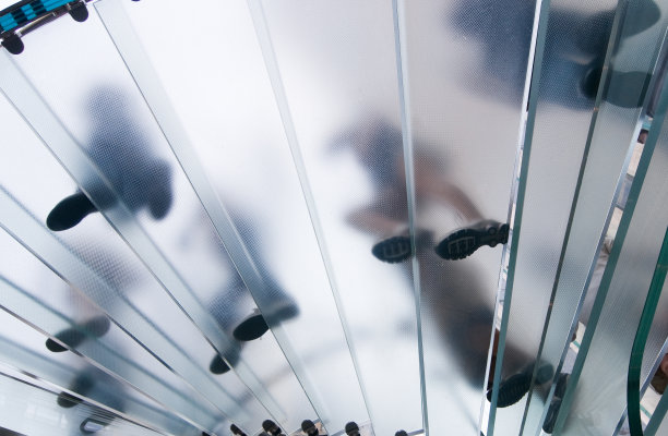 人们走在弯曲的玻璃楼梯上图片下载