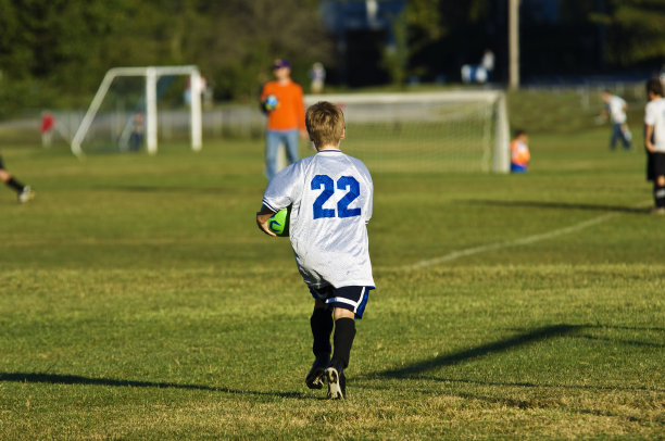 足球运动员在足球场上带着足球跑步告诉教练图片下载