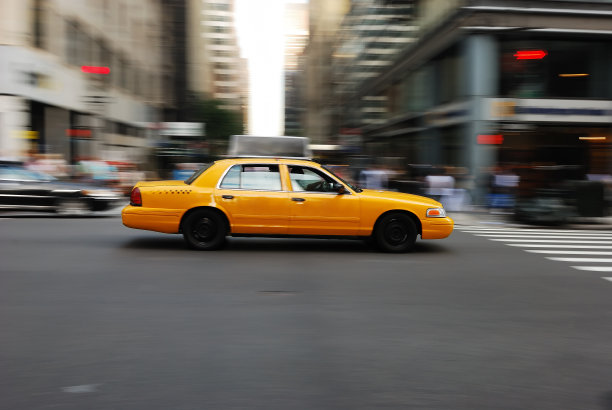 黄色出租车在街上快速行驶图片下载
